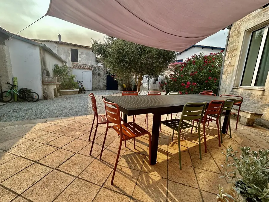 Patio avec grande table, oliviers et lauriers-roses
