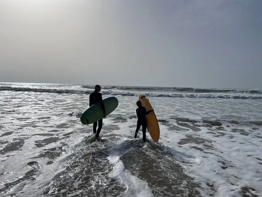 Deux surfeurs entrant dans les vagues